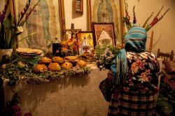 A woman in Teotitln del Valle presenting her offerings at the Day of the Dead altar in a relatives home.