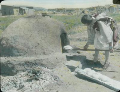 Pueblo woman baking bread in horno oven, New Mexico, unknown photographer (circa 1915). Palace of the Governors Photo Archive LS.1722, New Mexico History Museum, Santa Fe